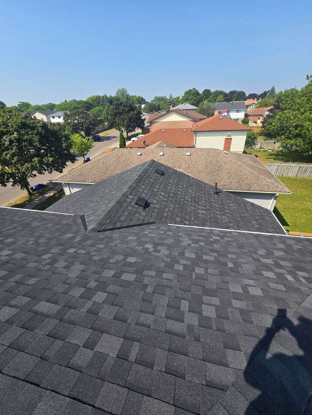 Newly installed asphalt shingle roofing in a suburban neighborhood, showcasing durability and style.
