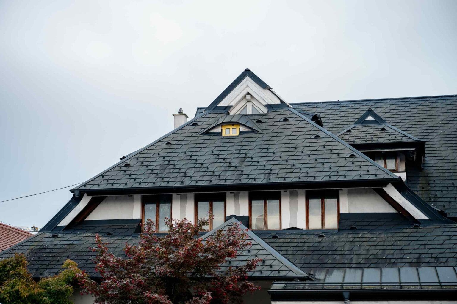 Modern slate roof with dormer windows on residential home. Perfect choice for durable roofing solutions.